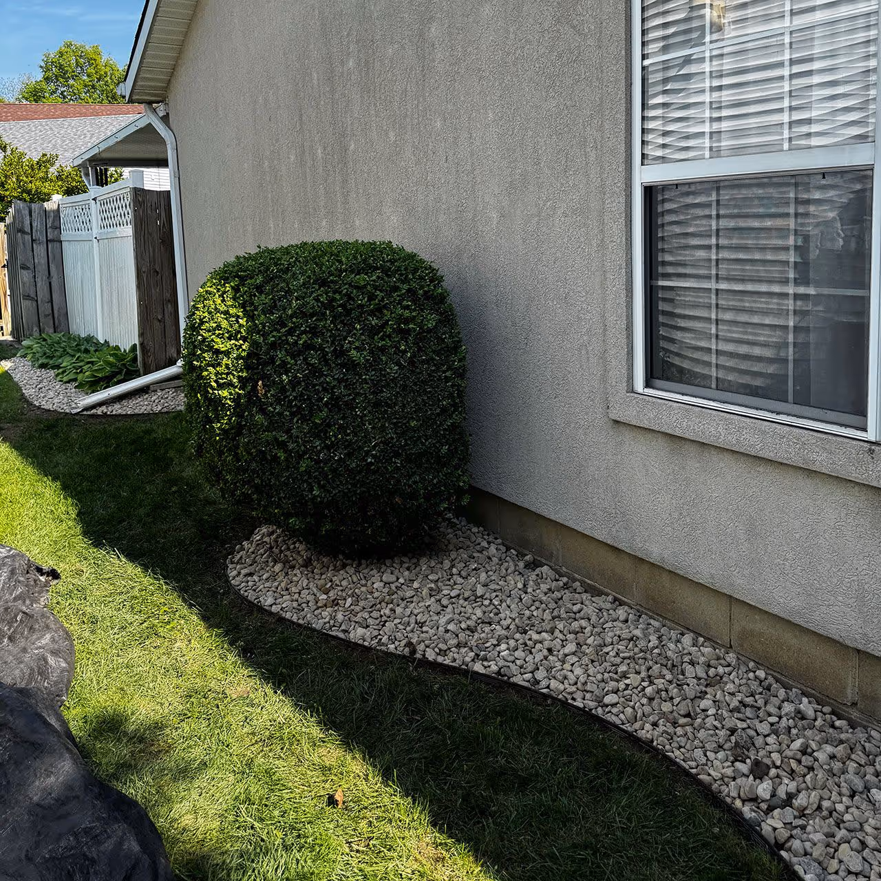 Landscaping installation with decorative stone and plant layout