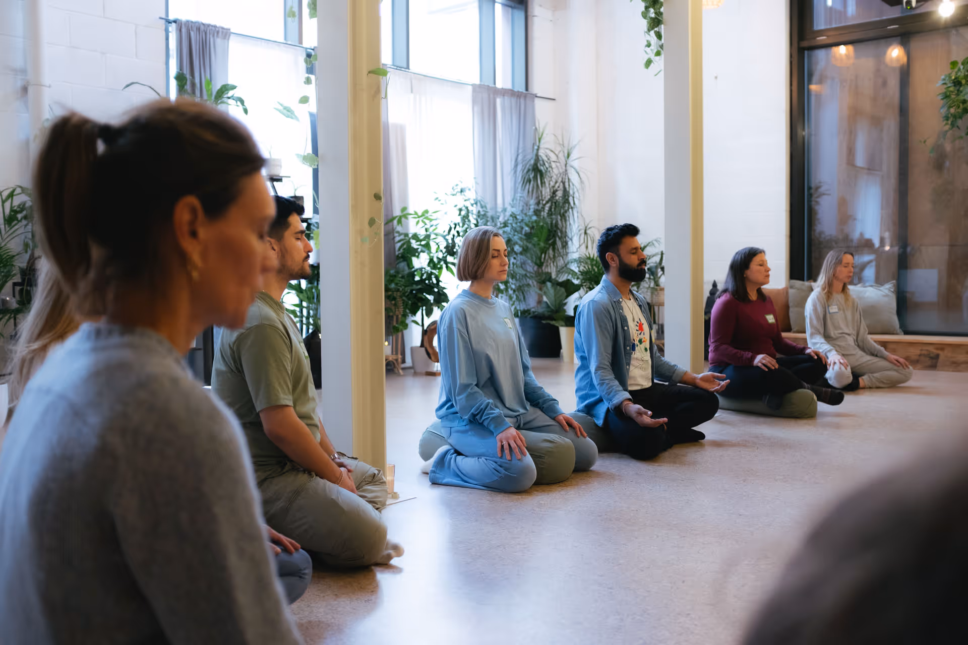 Trainees sitting cross-legged in a circle with eyes closed during Bali Breathwork facilitator training