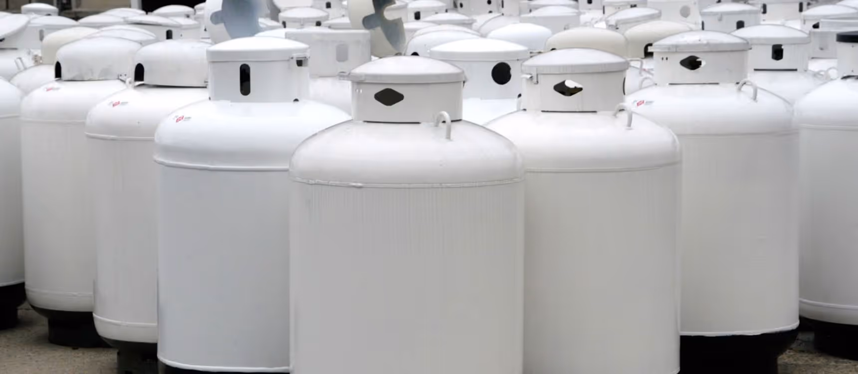 A pile of white propane tanks
