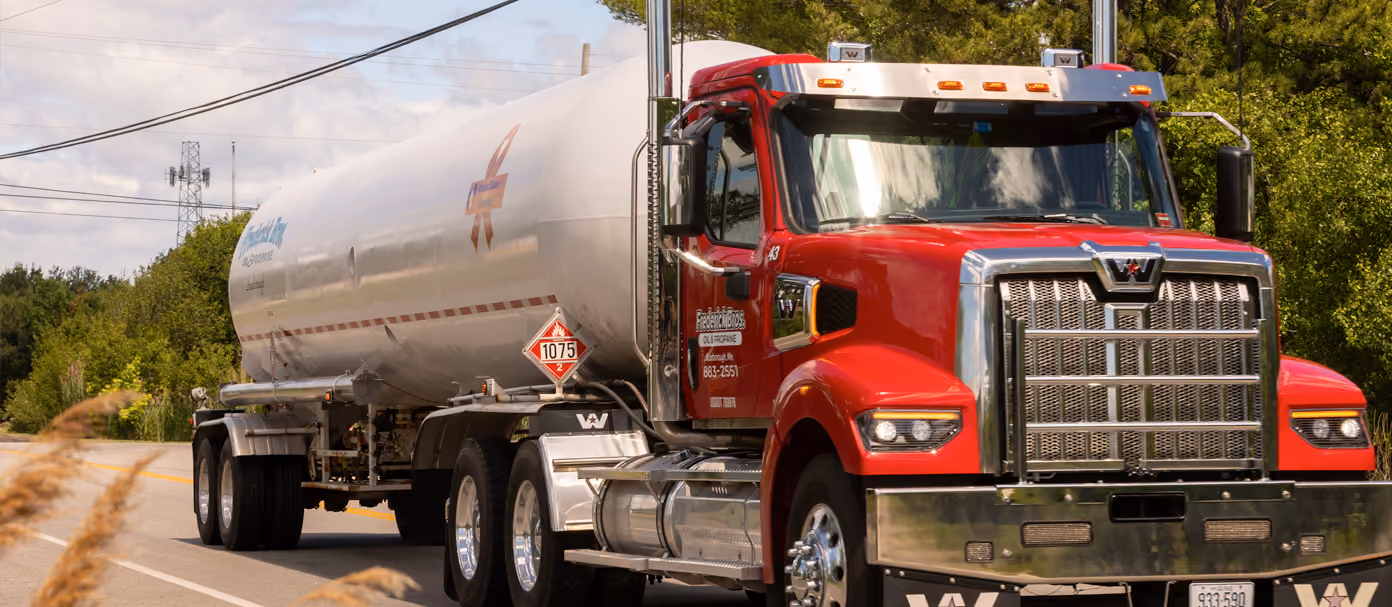 Red commercial propane delivery truck driving on a road.