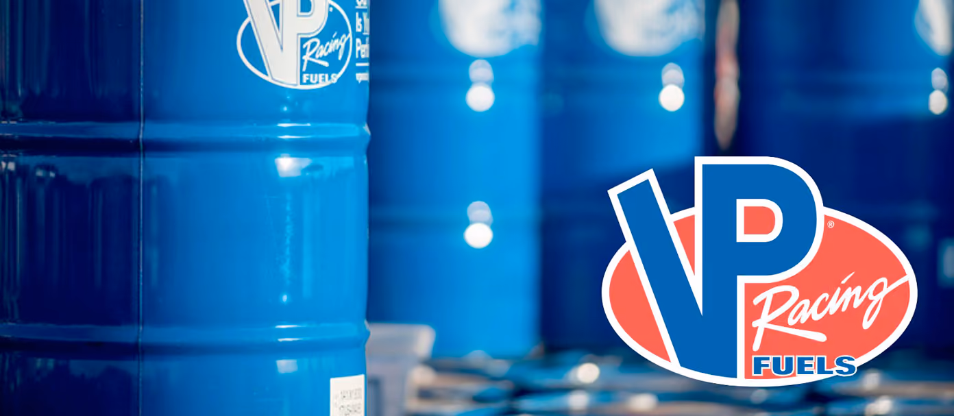 Blue VP Racing Fuels barrels with the VP Racing Fuels logo in the foreground.