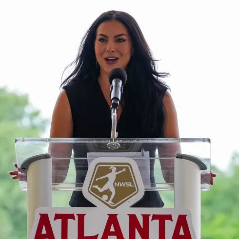 Baillie Burmaster speaks at a podium with the NWSL logo and Atlanta signage.