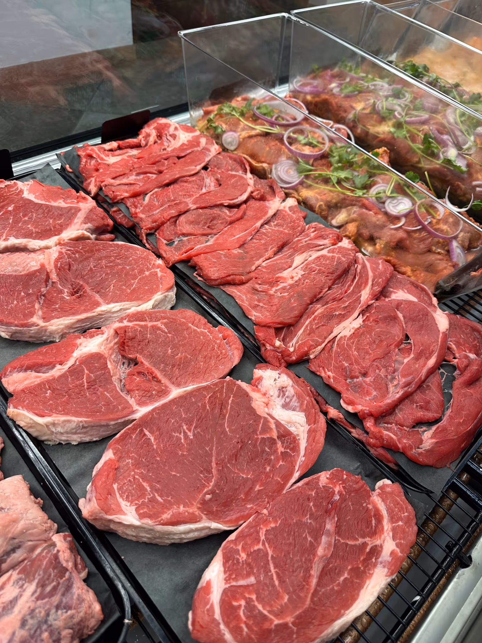 A display of raw meat with a close up of raw steak.