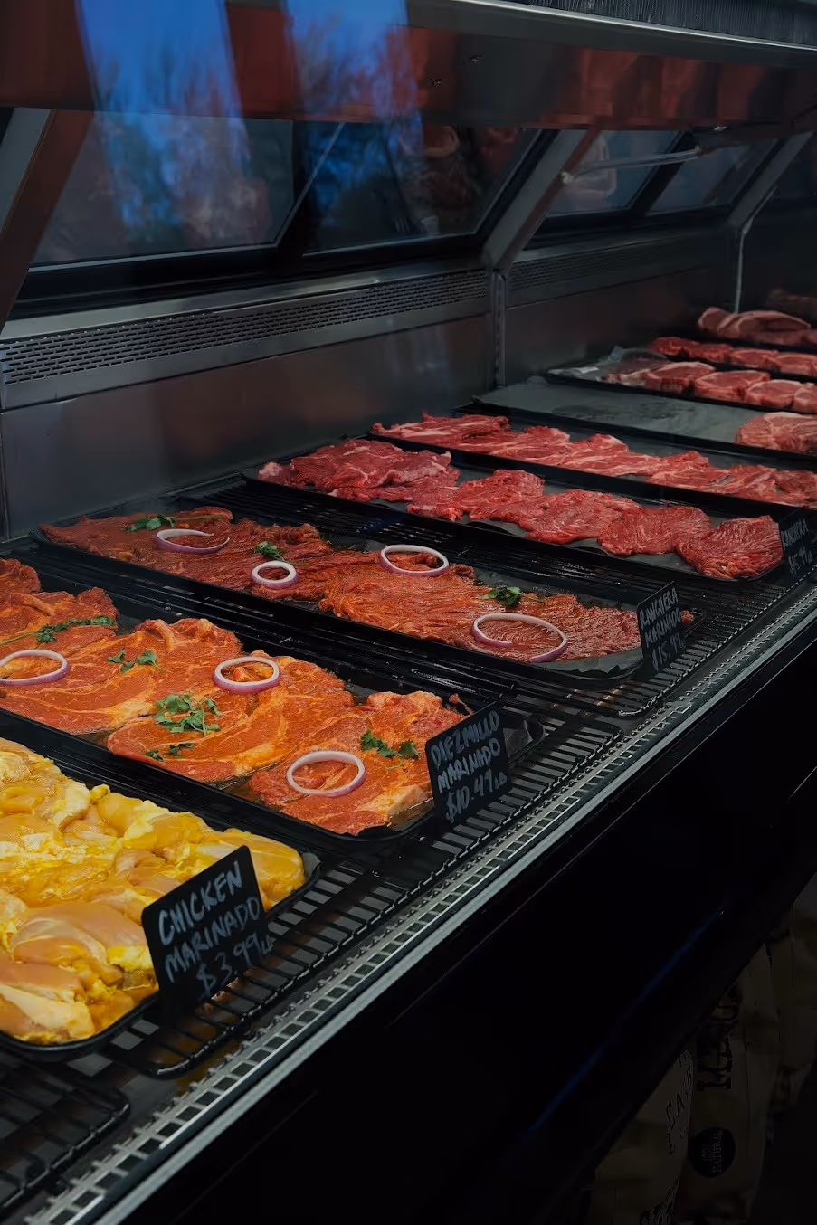 A meat display in a store with various cuts of meat.