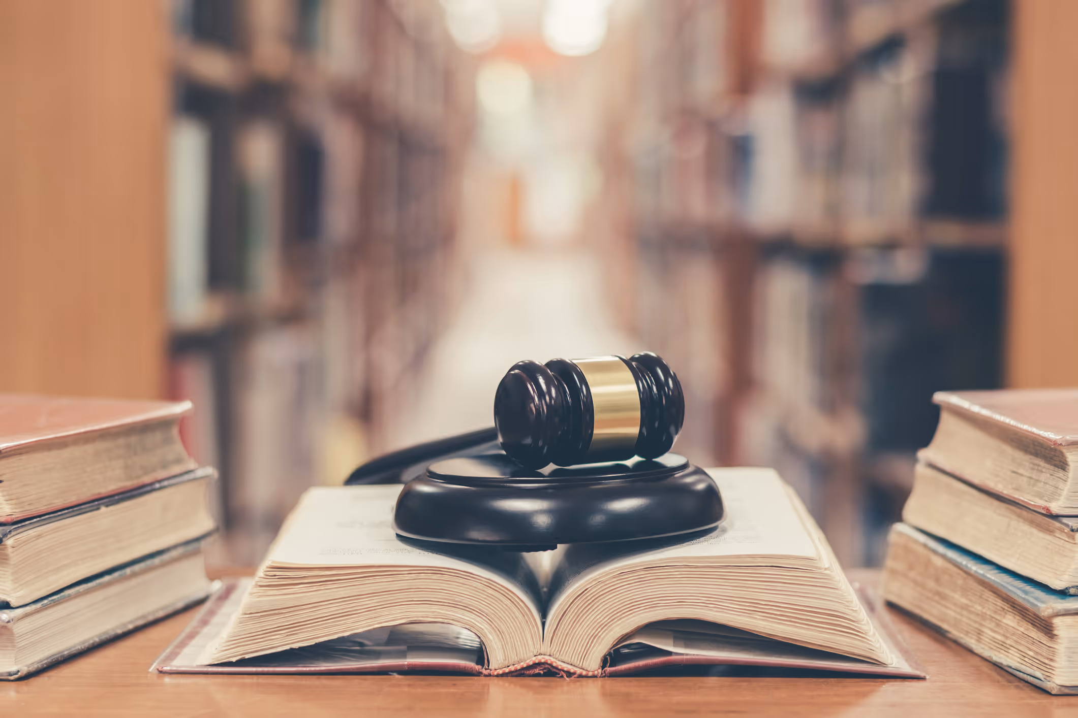 Judge gavel on book in library|Law Firm Cases in Orange County|Judge Holding Documents|Business man signing a contract