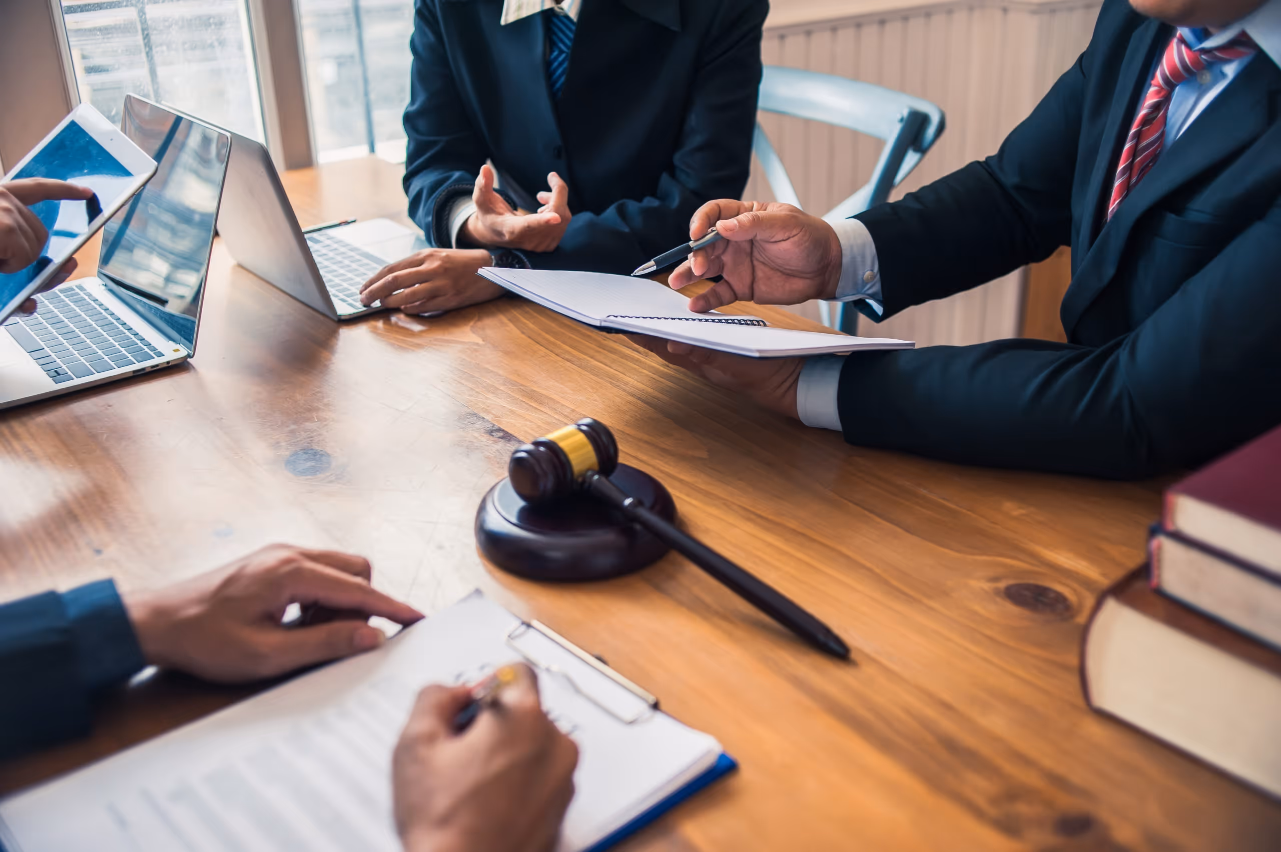 Lawyers and clients gathered around a table for arbitration proceedings