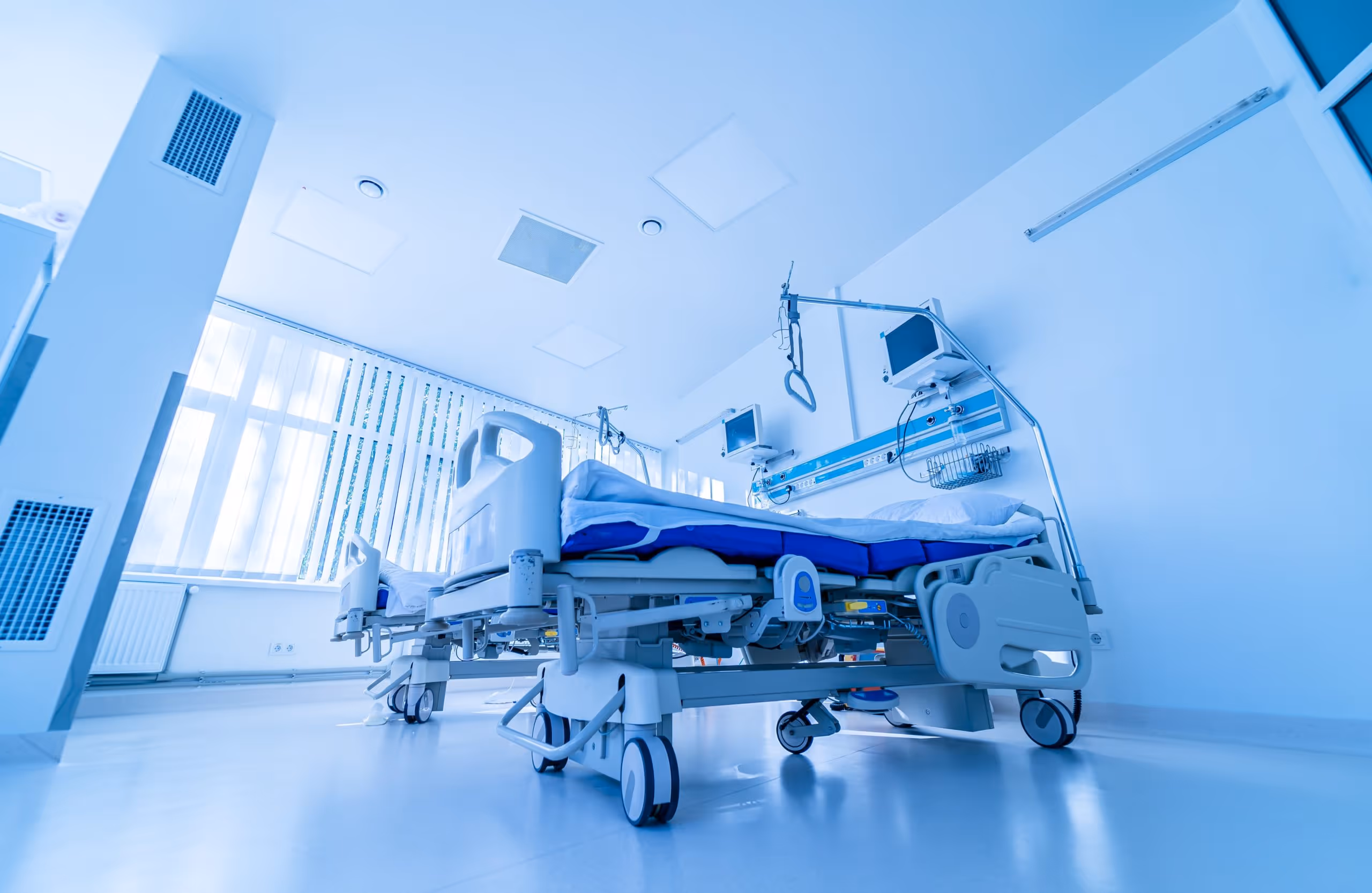 Empty hospital bed in a room awaiting patient use