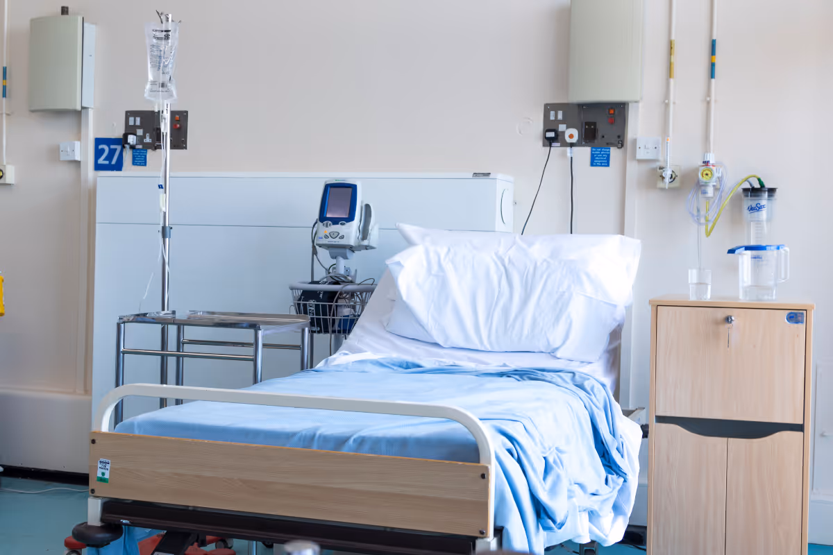 An empty, recently rumpled hospital bed after a patient has died.