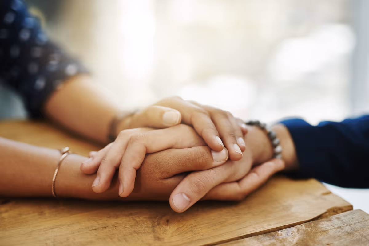 After a loss, family members hold hands to comfort one another.