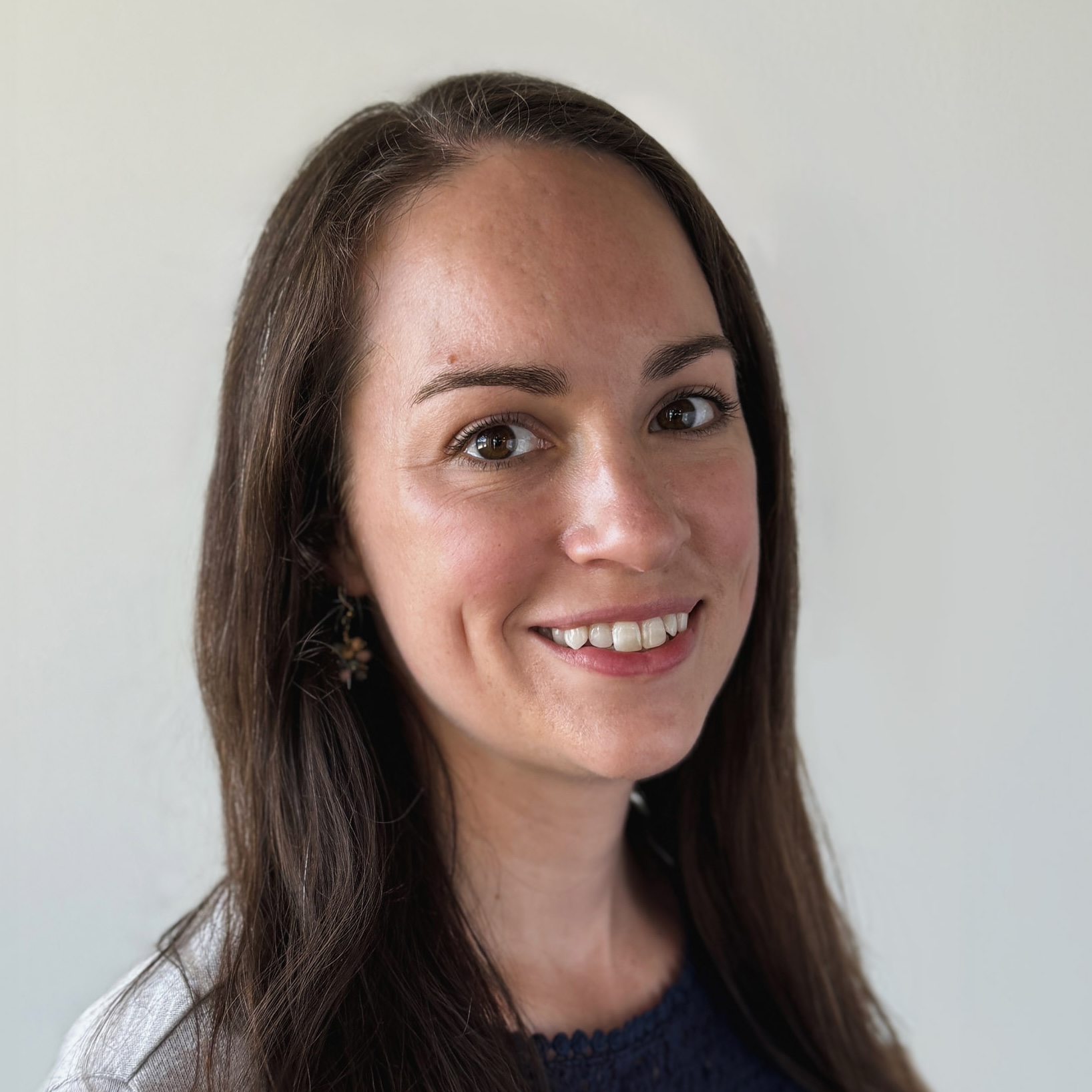 Sarah Wegwerth's headshot. Smiling woman with long brown hair wearing a navy top and light cardigan against a plain background.