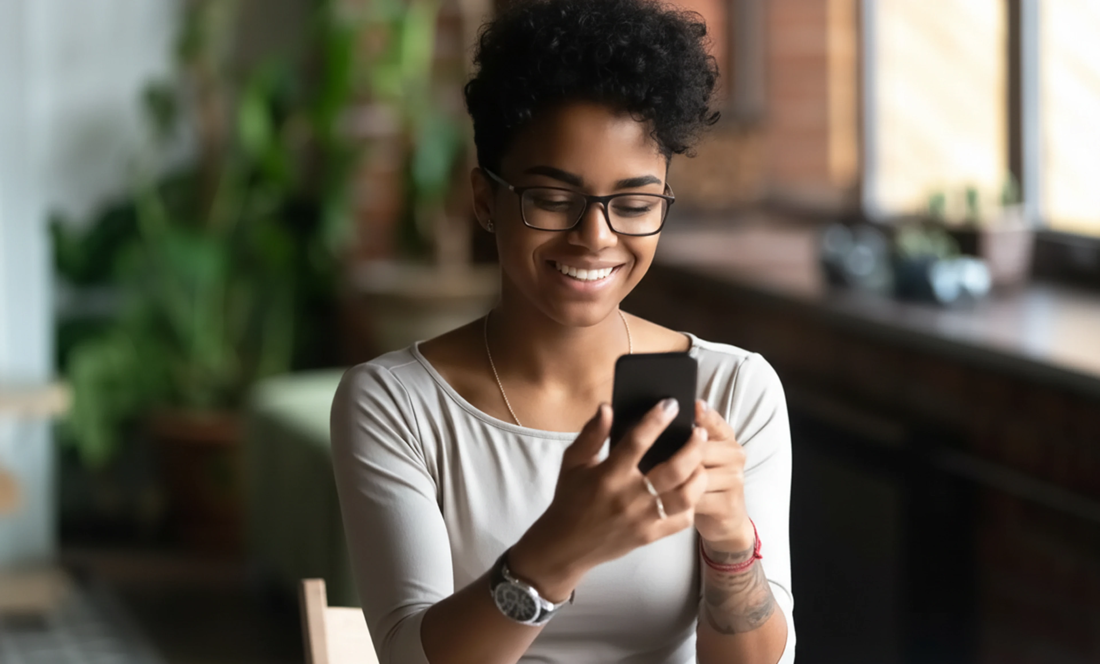 A learner using a mobile phone to access an online assessment in a casual, real-world environment.