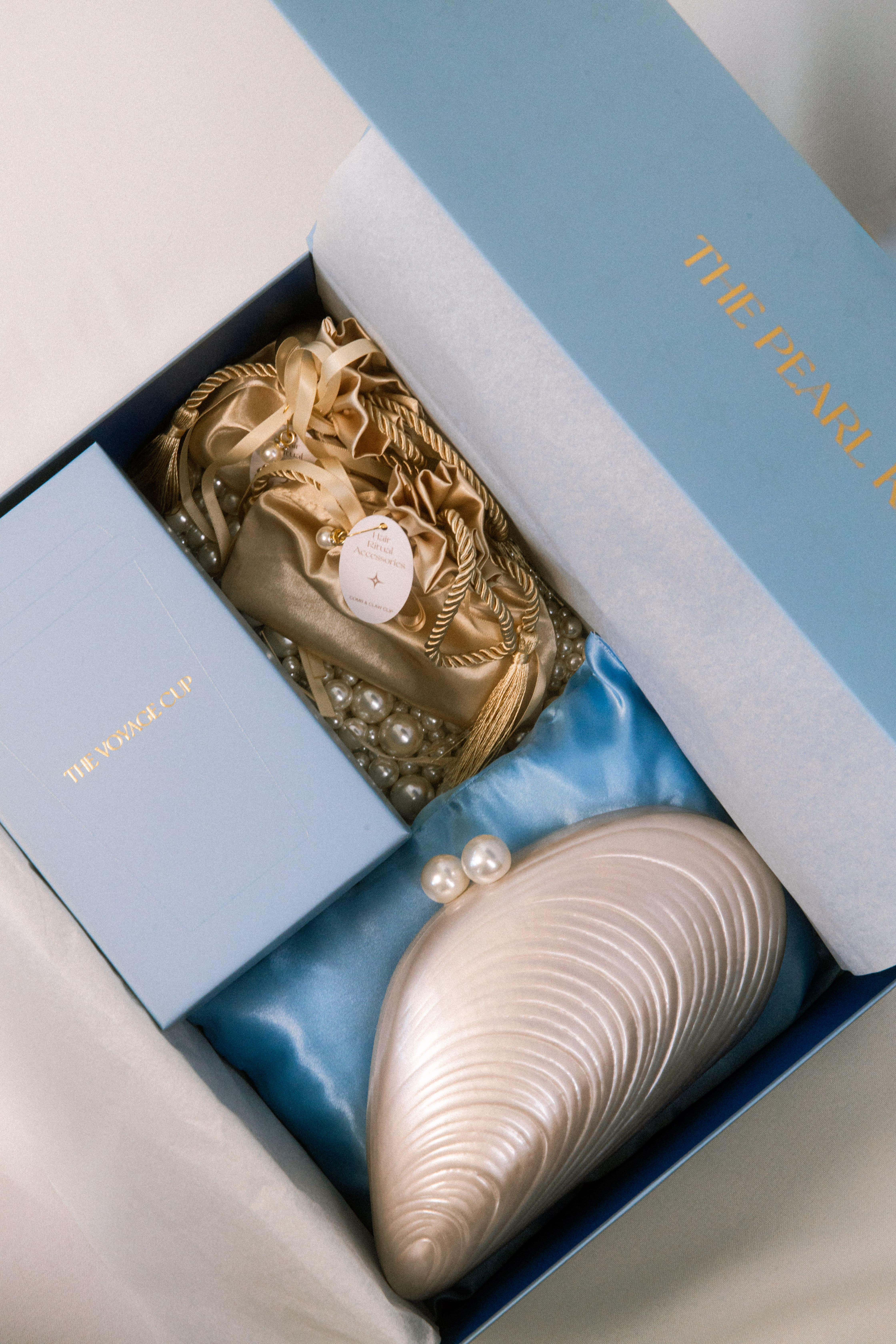 Close-up of a woman's face with natural freckles, glossy lips, rosy cheeks, and strands of dark hair partially covering her face.