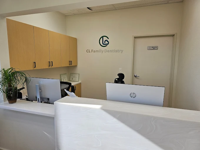 Front reception desk at CL Family Dentistry showing the green CL Family Dentistry logo on the wall behind the check in counter
