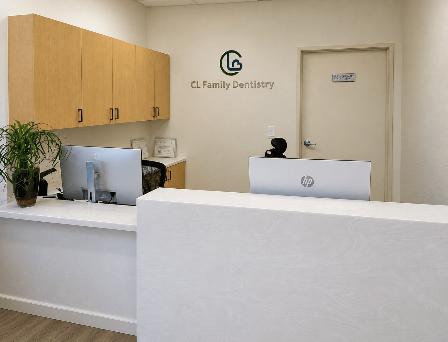 Front reception desk at Choi & Lee Family Dentistry showing the green CL Family Dentistry logo on the wall behind the check in counter