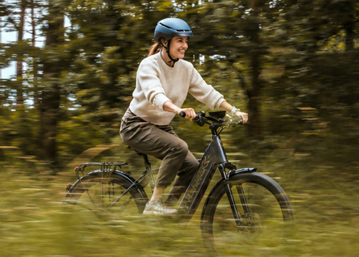 Two cyclists riding electric bikes on a wooded trail