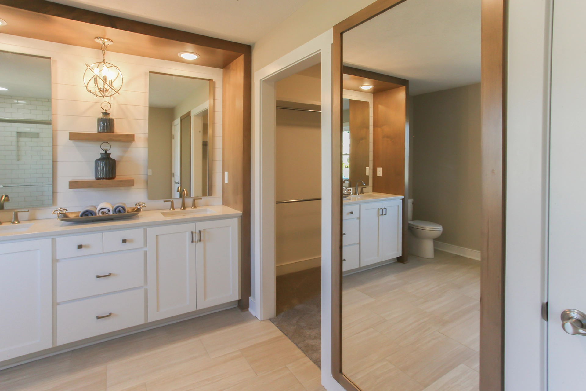 Bathroom with jack and jill sinks, a walk-in closet, and giant mirror