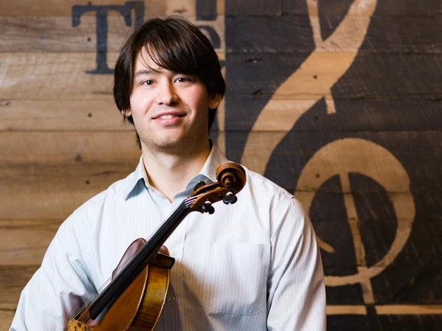 Violin teacher at Powell Academy of Music in Powell, Ohio holding his violin