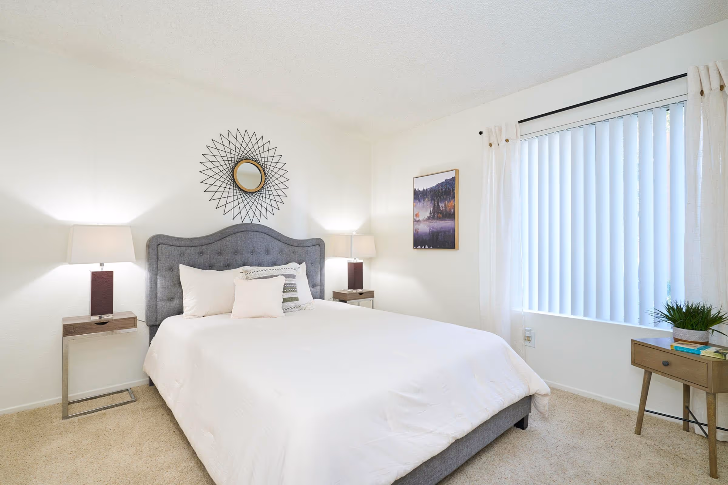 Bedroom with bed, dresser, and bedside tables featuring large window