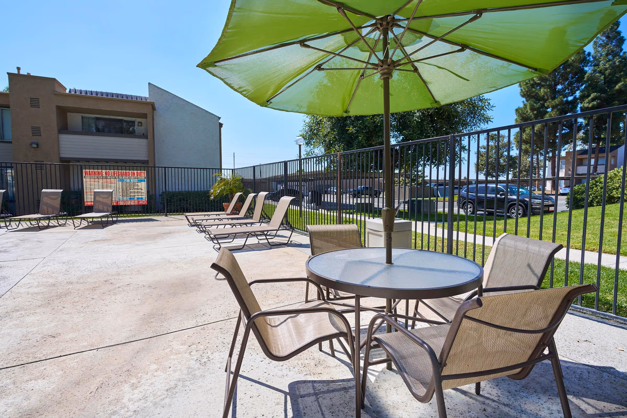 Tables and chairs with umbrella near swimming pool
