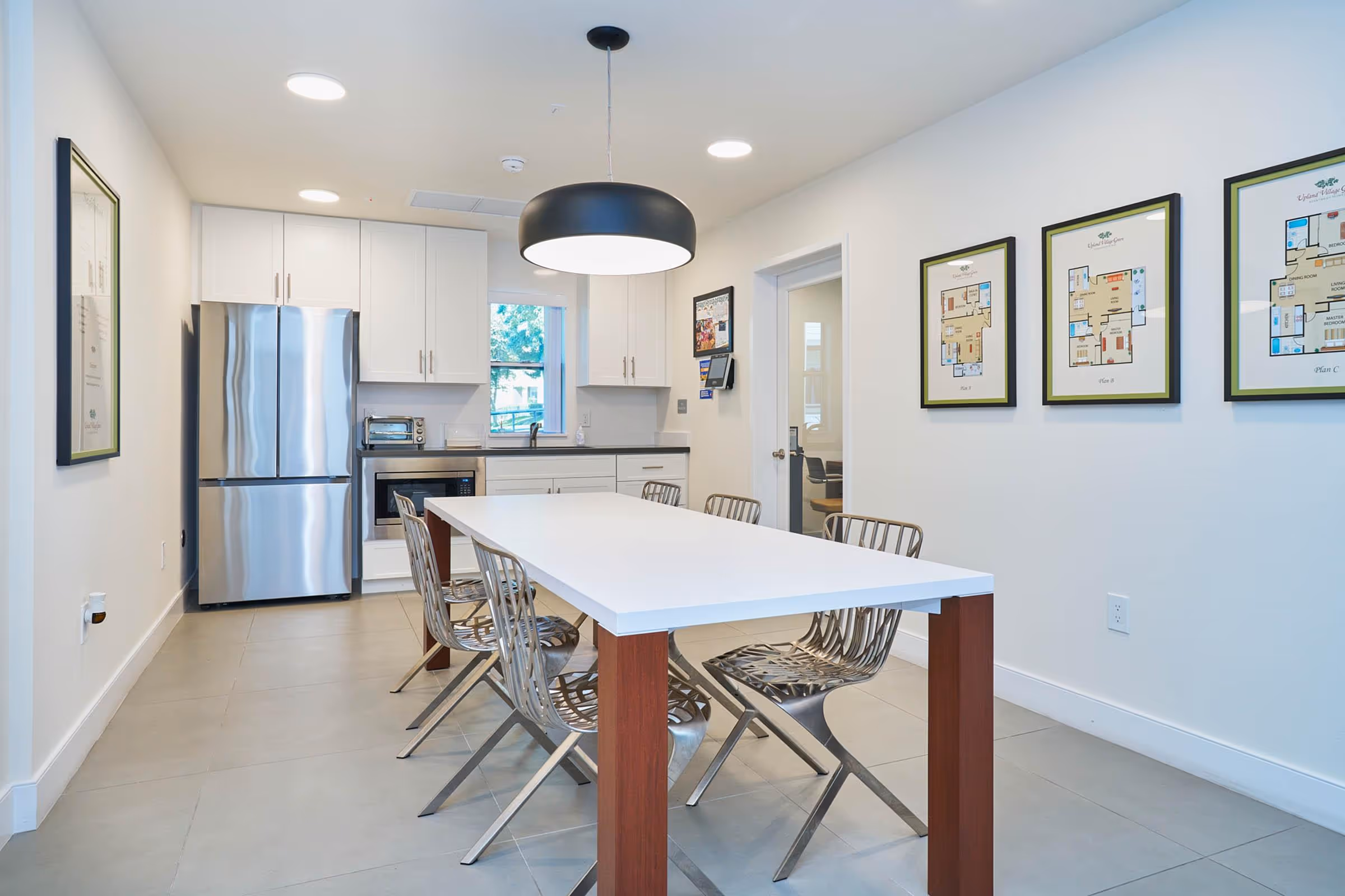 Lounge meeting room with table and chairs featuring kitchenette with refrigerator