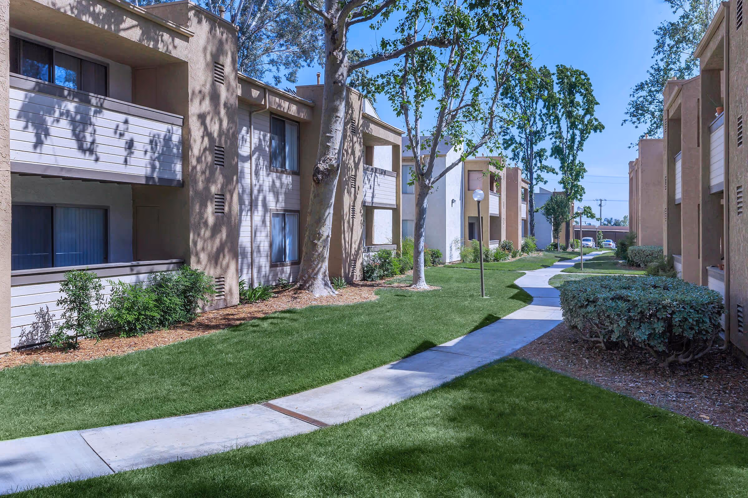 Exterior of apartment homes with walking paths and greenery