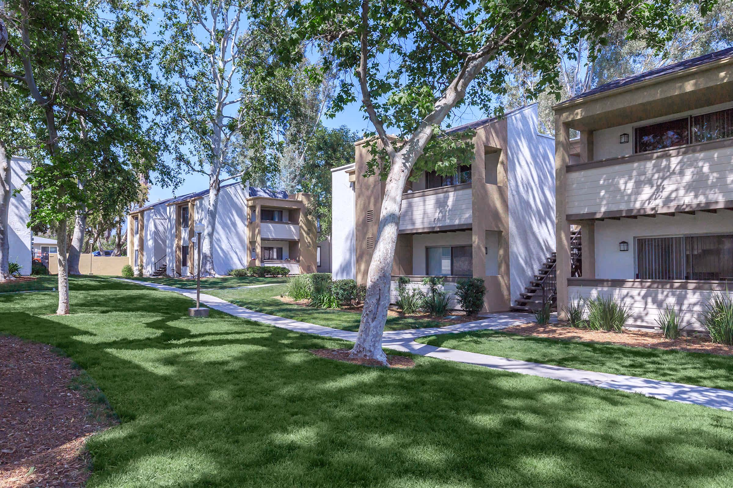 Exterior of apartment homes with walking paths and greenery
