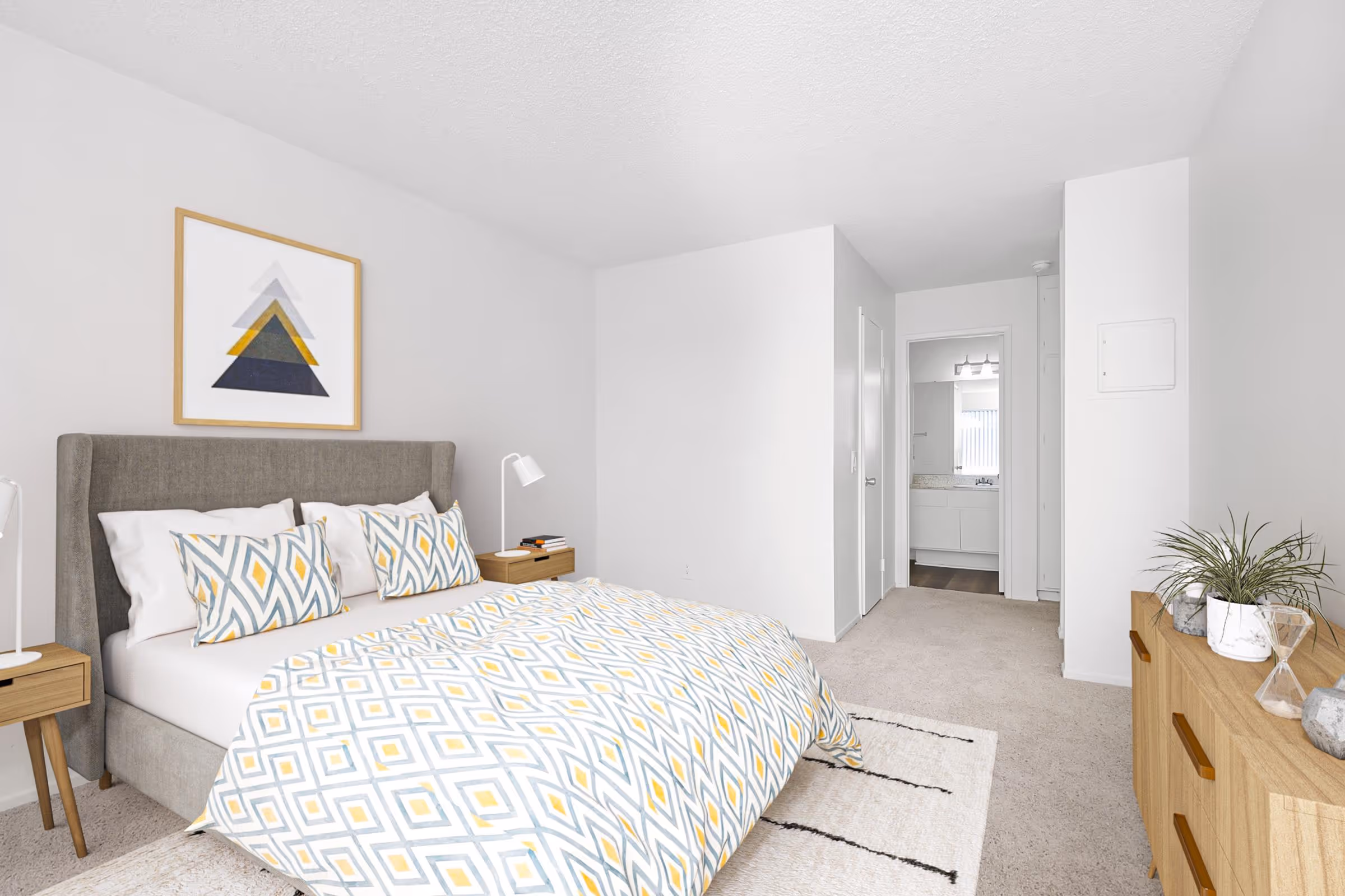 Virtually staged bedroom featuring bed, wall art, rug, and bedside tables