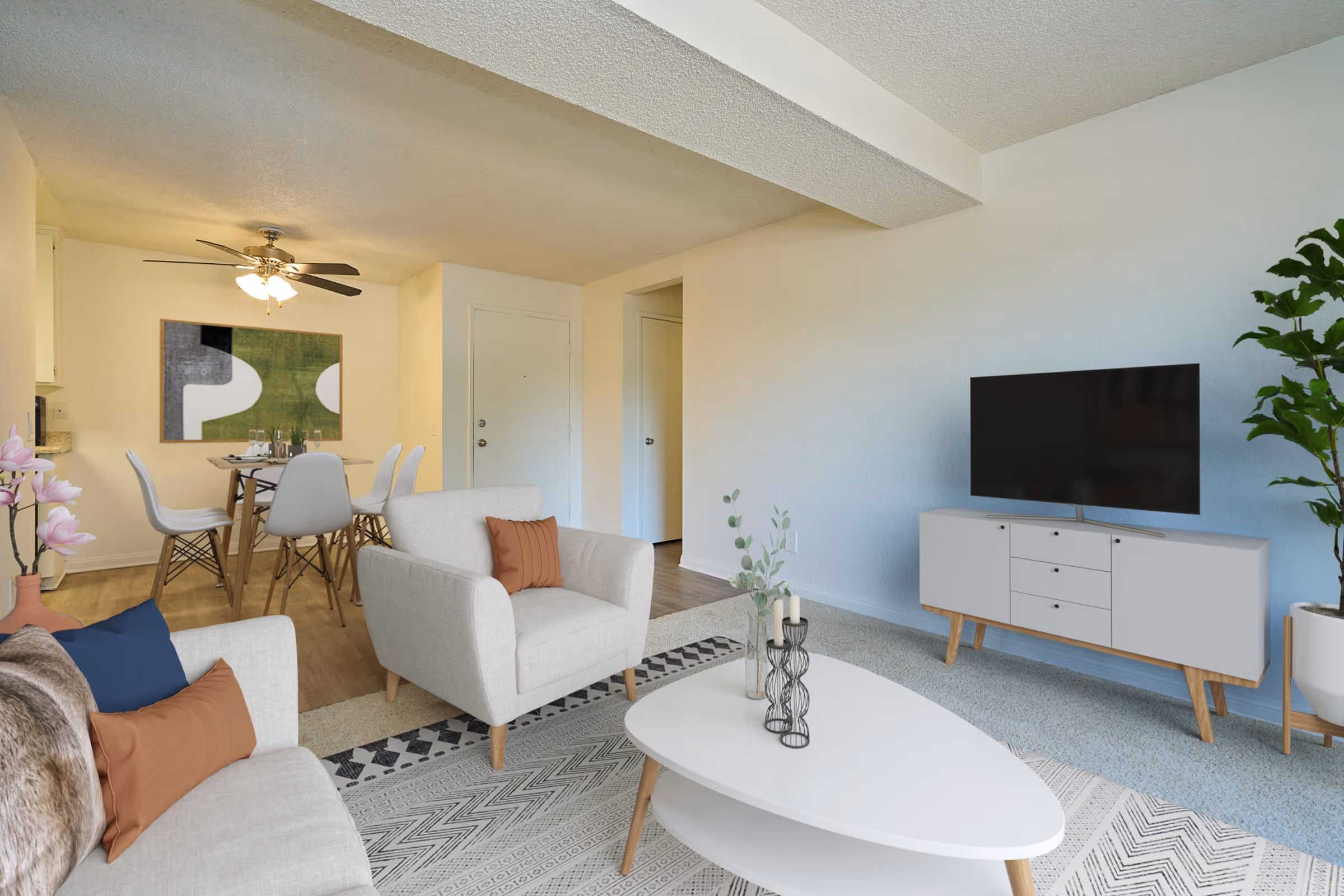 Wide view of Virtually staged living area featuring sofa, coffee table, and large window and dining area with table and chairs