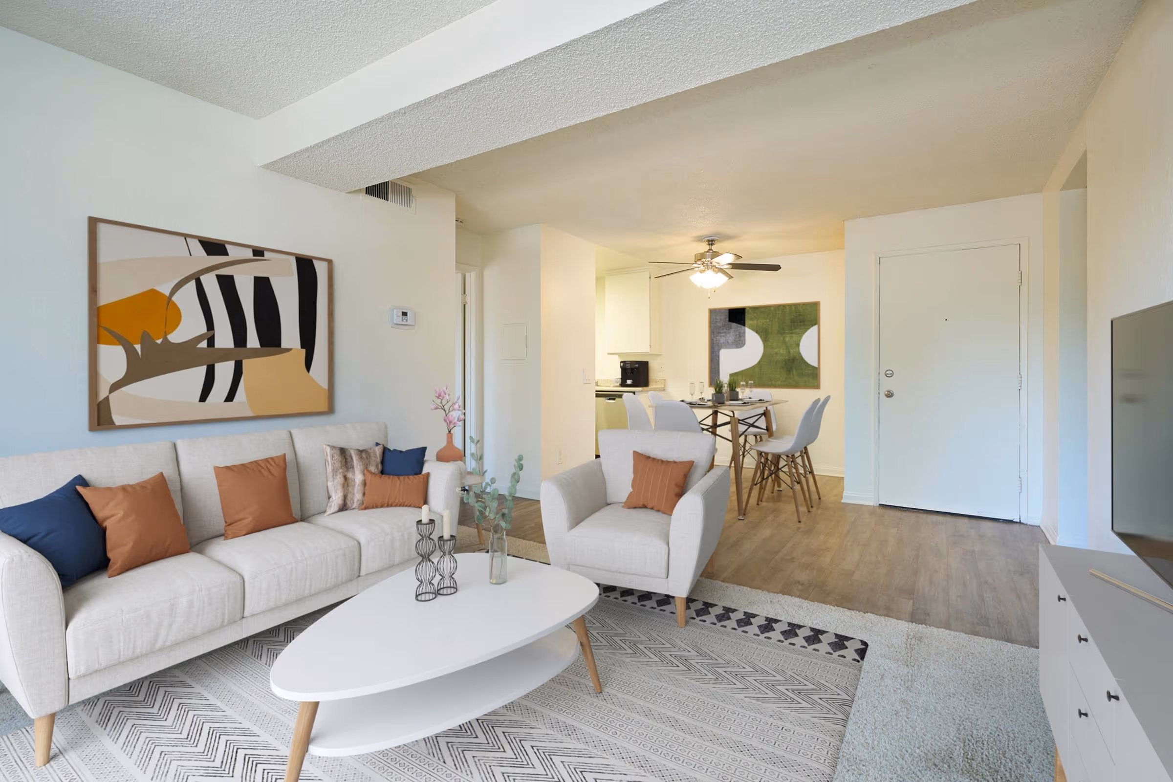 Wide view of Virtually staged living area featuring sofa, coffee table, and large window and dining area with table and chairs