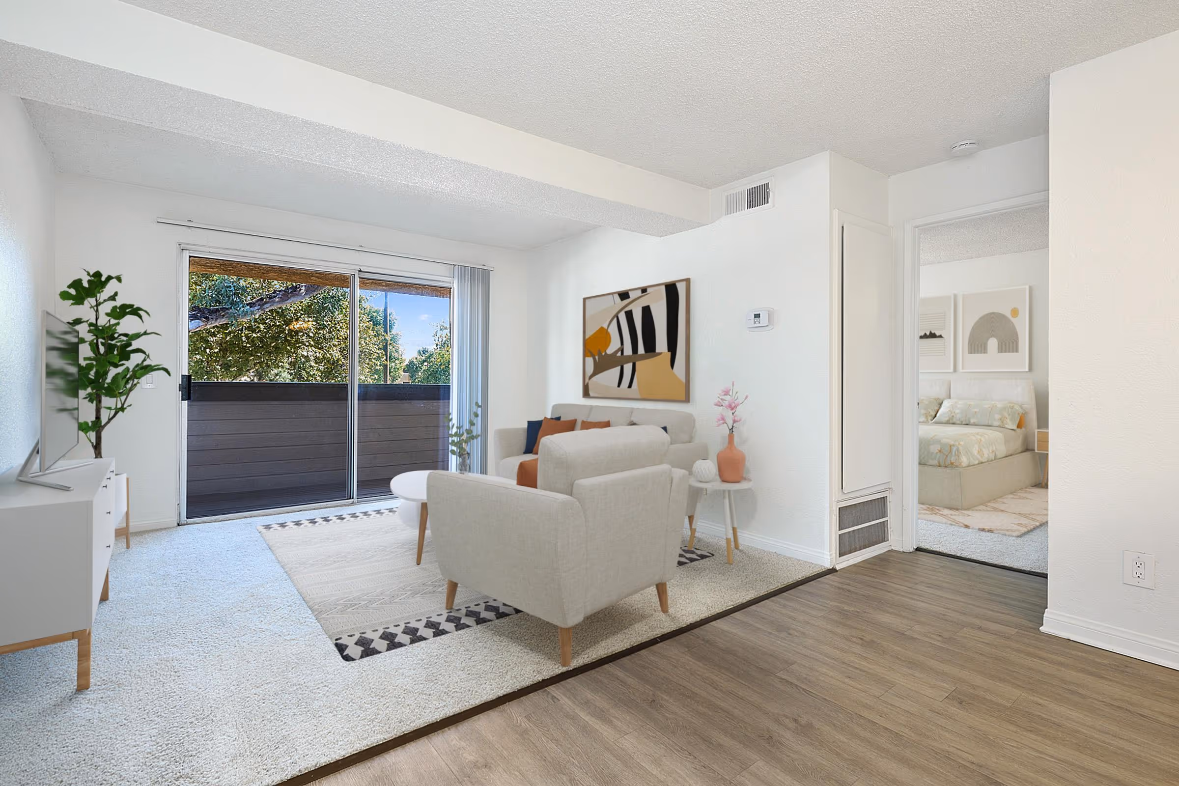 Virtually staged living area featuring sofa, coffee table, and tv and view of patio doors