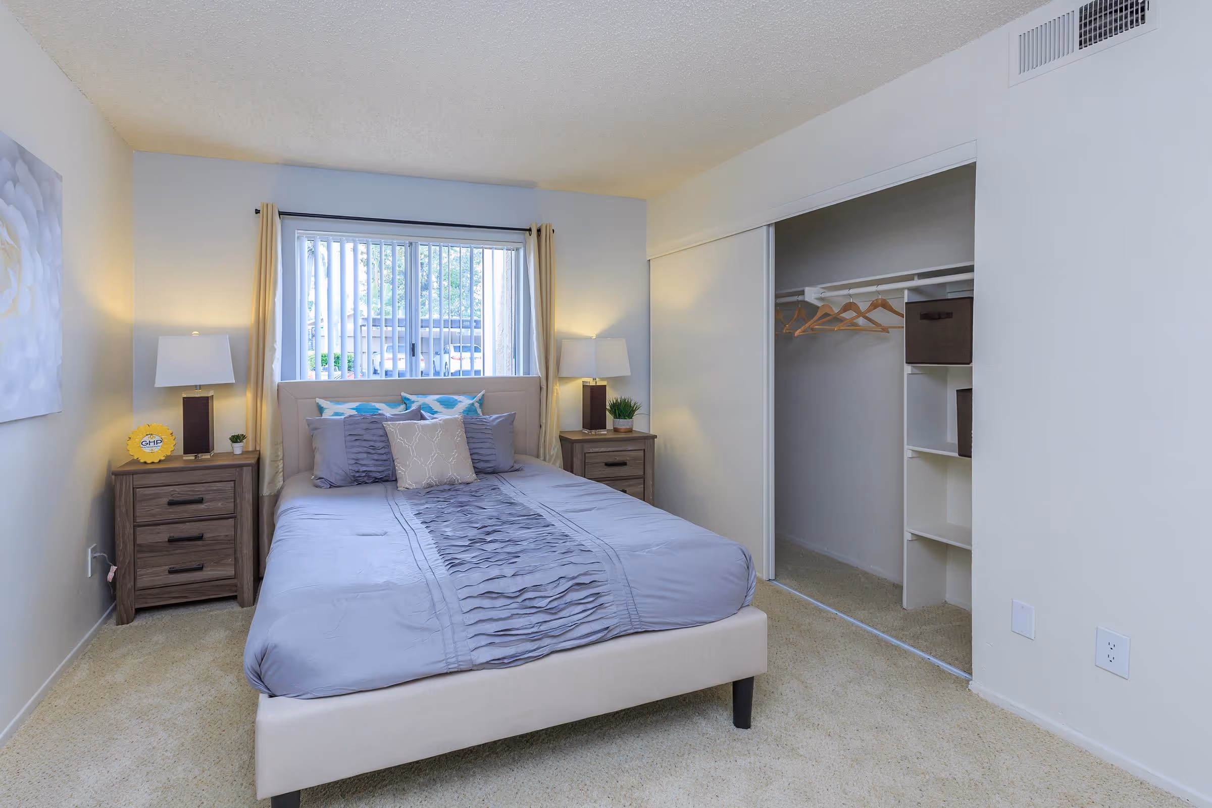 Bedroom featuring bed, bedside tables with lamps, and closet