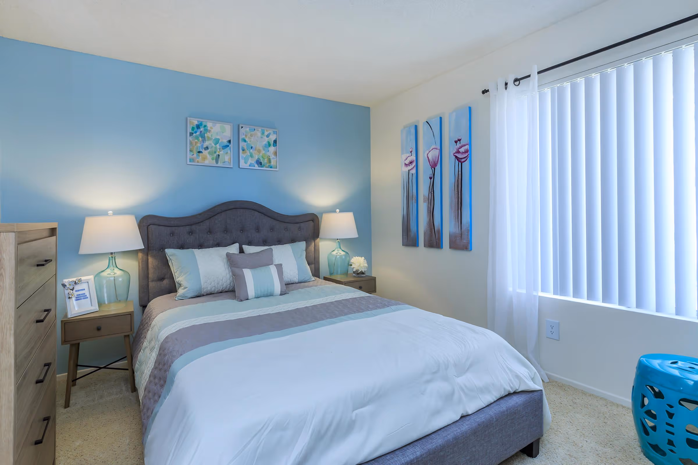 Bedroom featuring bed, bedside table and large window
