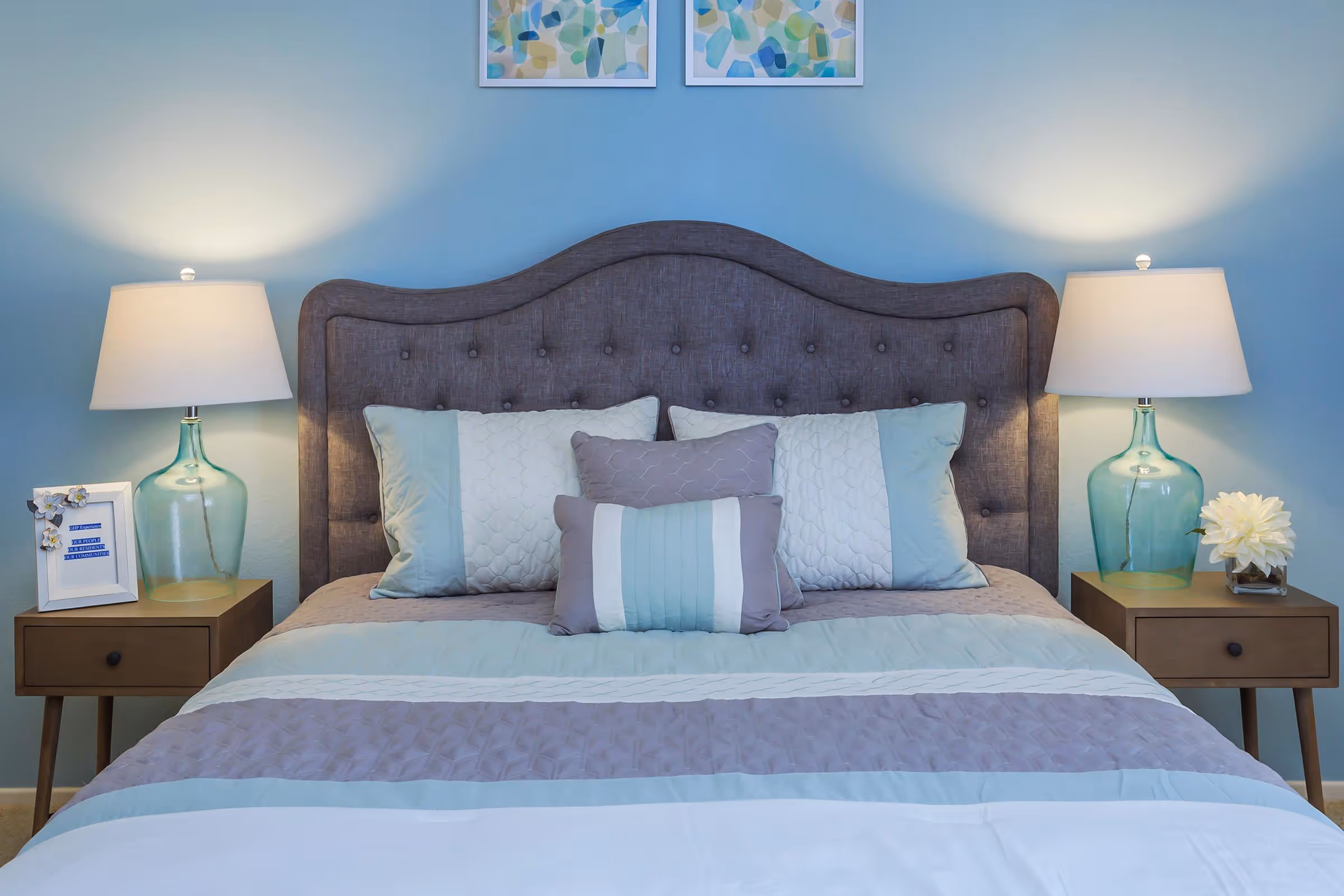 Virtually staged bedroom featuring bed, bedside tables with lamp, and wall art