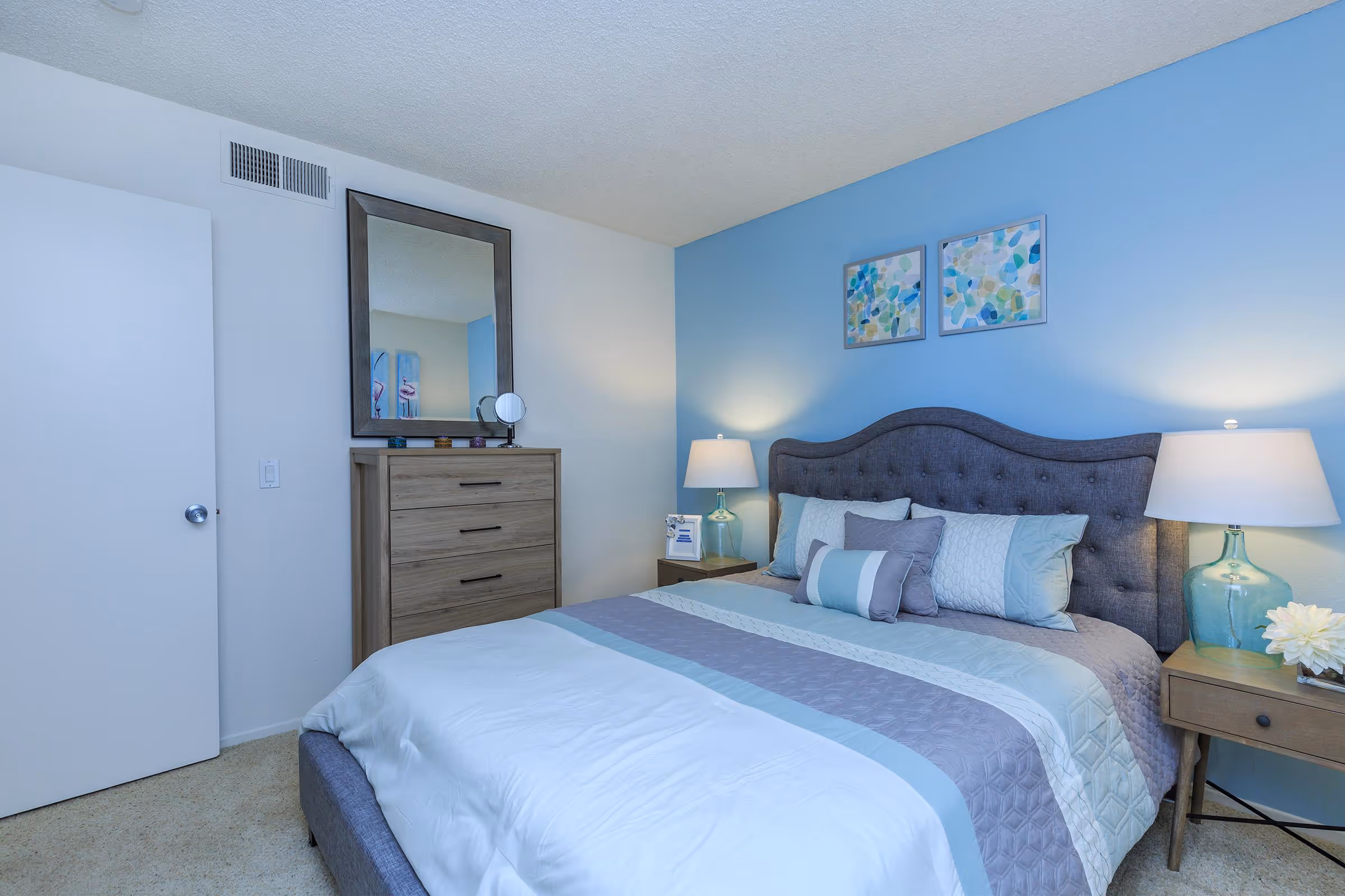 Virtually staged bedroom featuring bed, bedside tables with lamp, and wall art