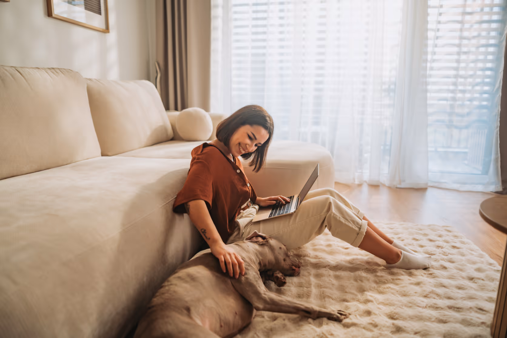 Woman with pet next to sofa stock image