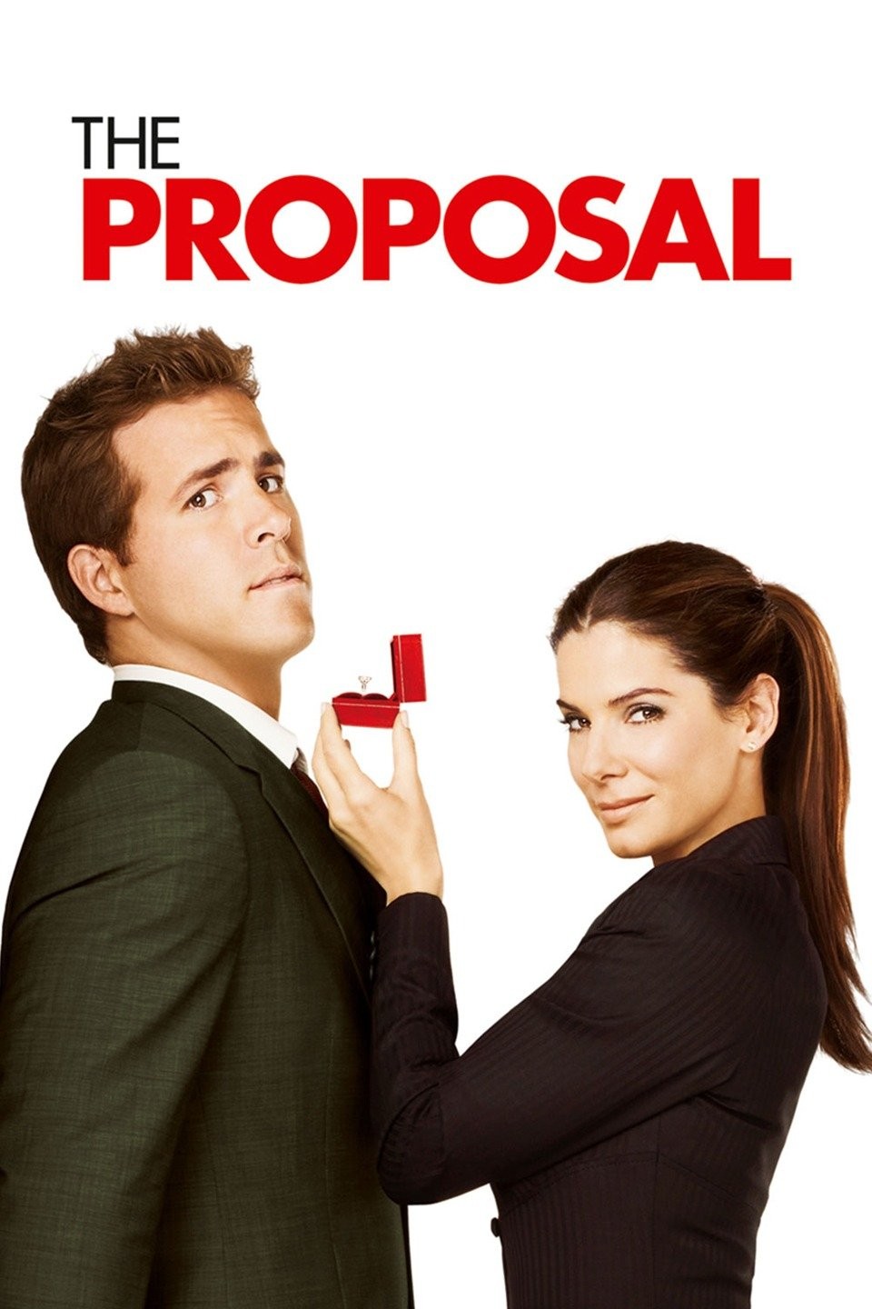 Man in a dark suit nervously biting his lip as a woman in a black outfit holds up an open red ring box with a diamond ring, under red text reading 'THE PROPOSAL'.