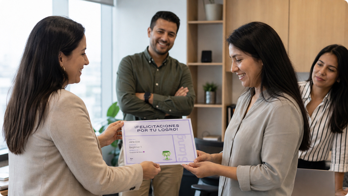 Woman receiving an english certificate in an office while three colleagues watch and smile.