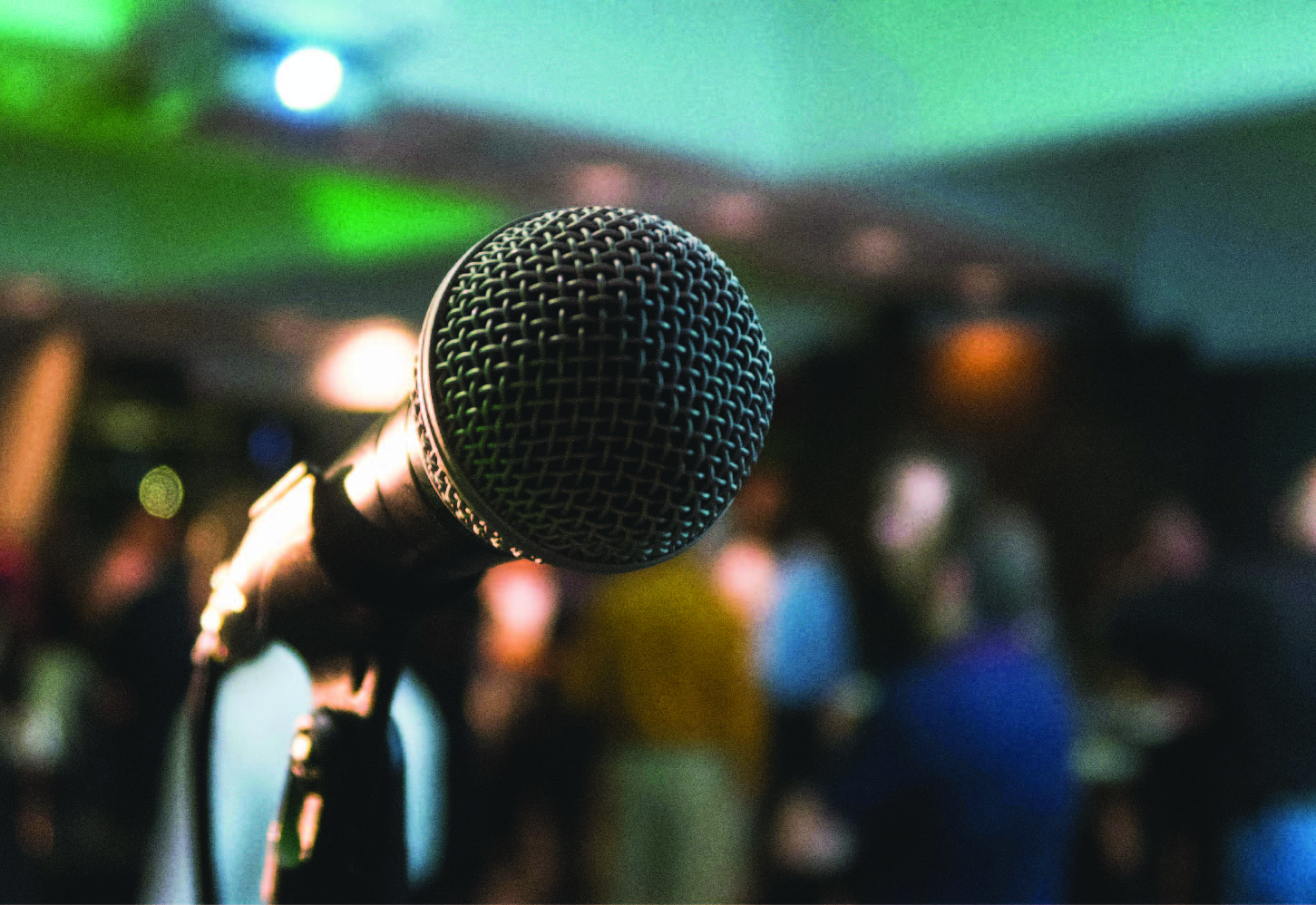 A microphone in front of a blurred out crowd.
