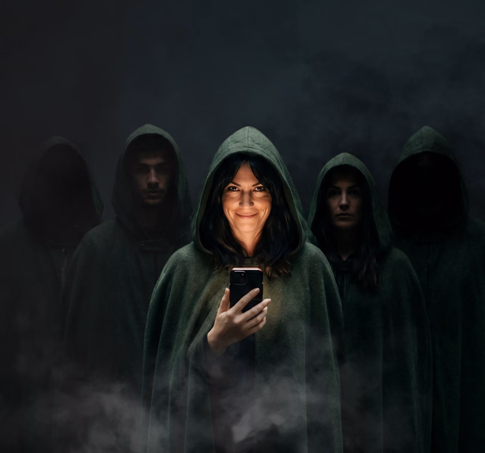 Group of five people in dark cloaks, one smiling in front holding a glowing smartphone.
