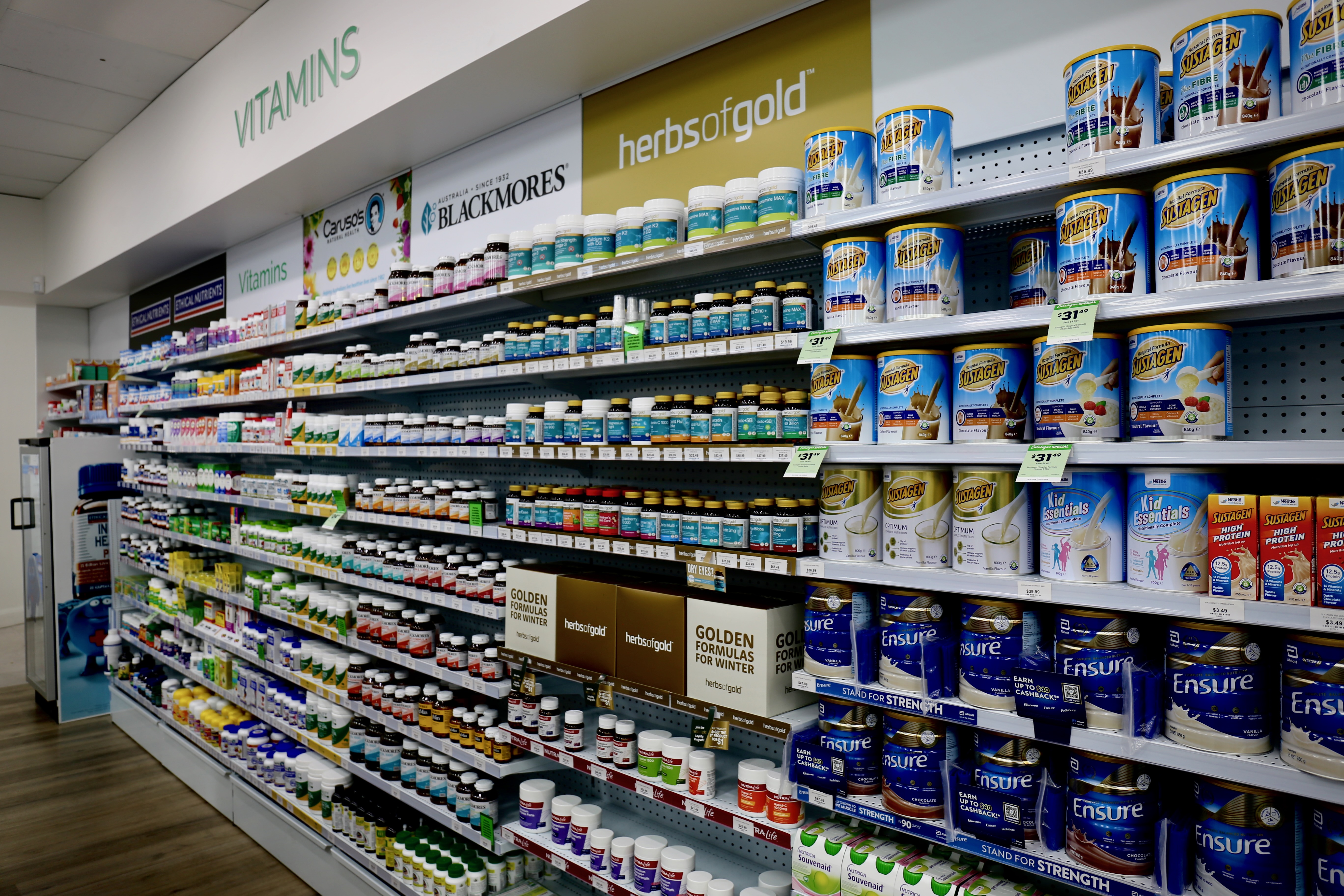 Well-stocked vitamins and supplements aisle at Southcity Community Pharmacy, featuring brands including Blackmores, Herbs of Gold