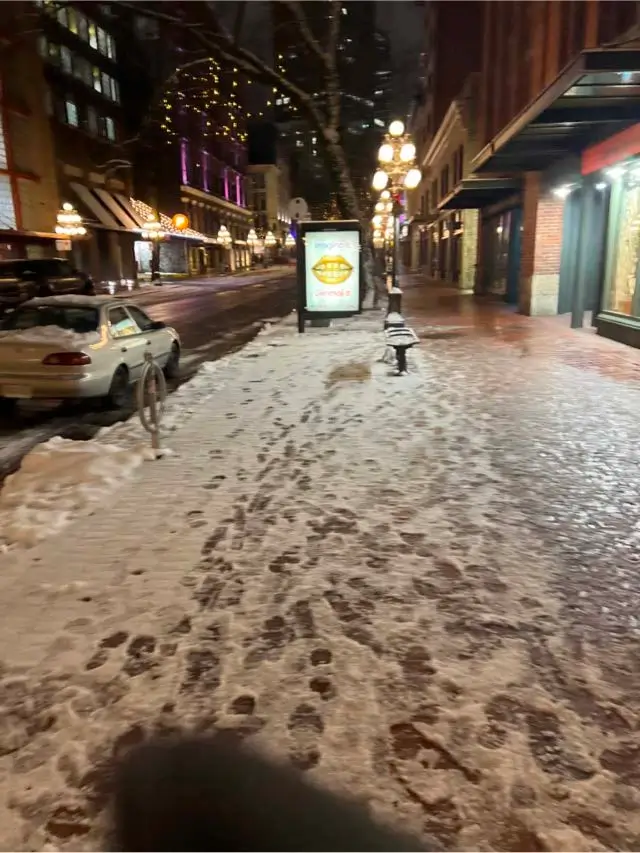 Snow-covered sidewalk near storefronts in Gastown, Vancouver
