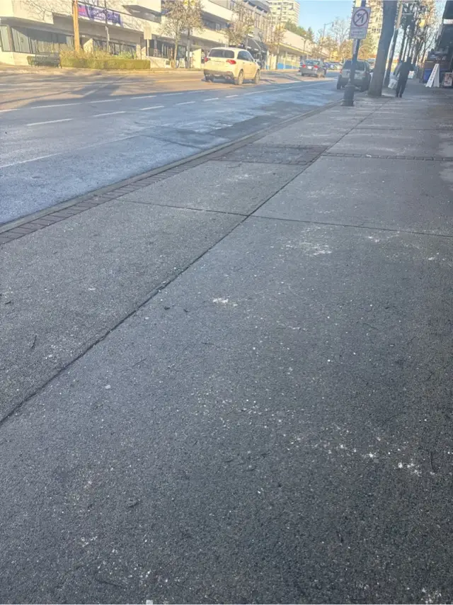 De-icing material applied to a commercial sidewalk in Downtown New Westminster