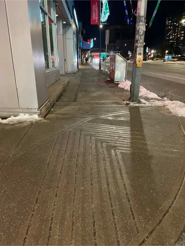 Cleared and de-iced commercial sidewalk near a transit stop in Metrotown, Burnaby