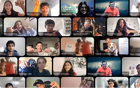 Grid of diverse people on a virtual video call, many smiling and making hand gestures or showing objects to the camera.