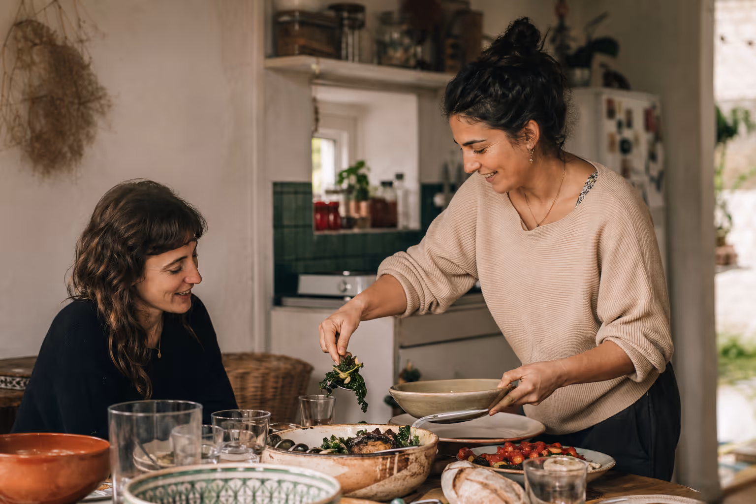 A local and traveler sharing a home-cooked meal at a kitchen table