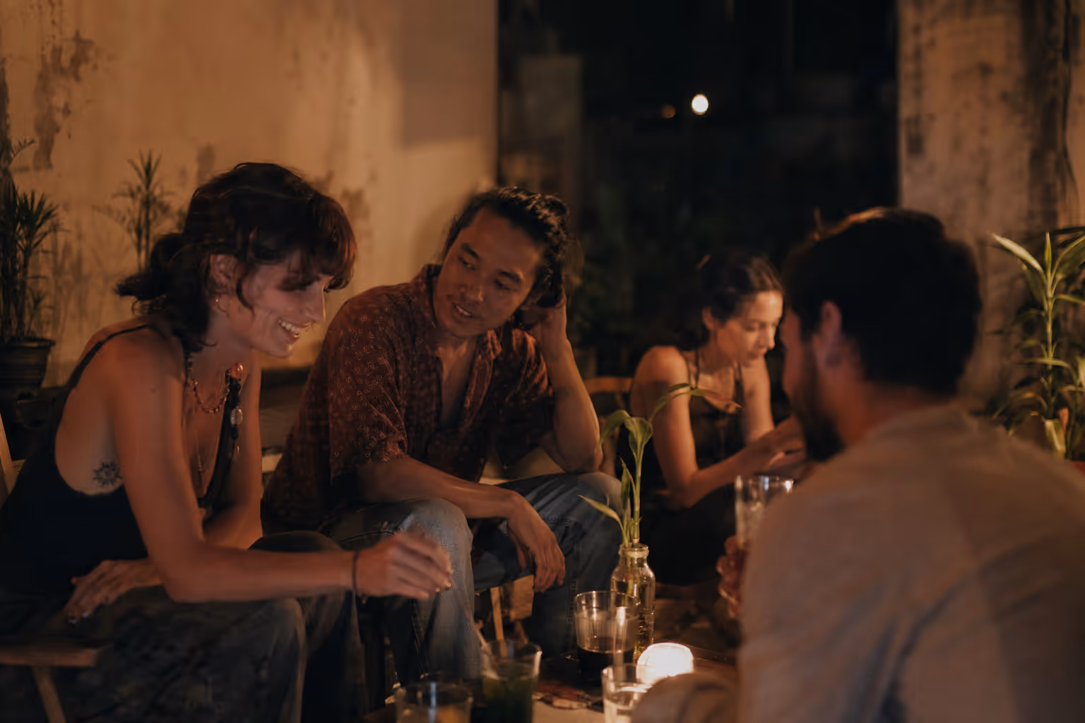 A group of friends sharing an evening dinner together by candlelight