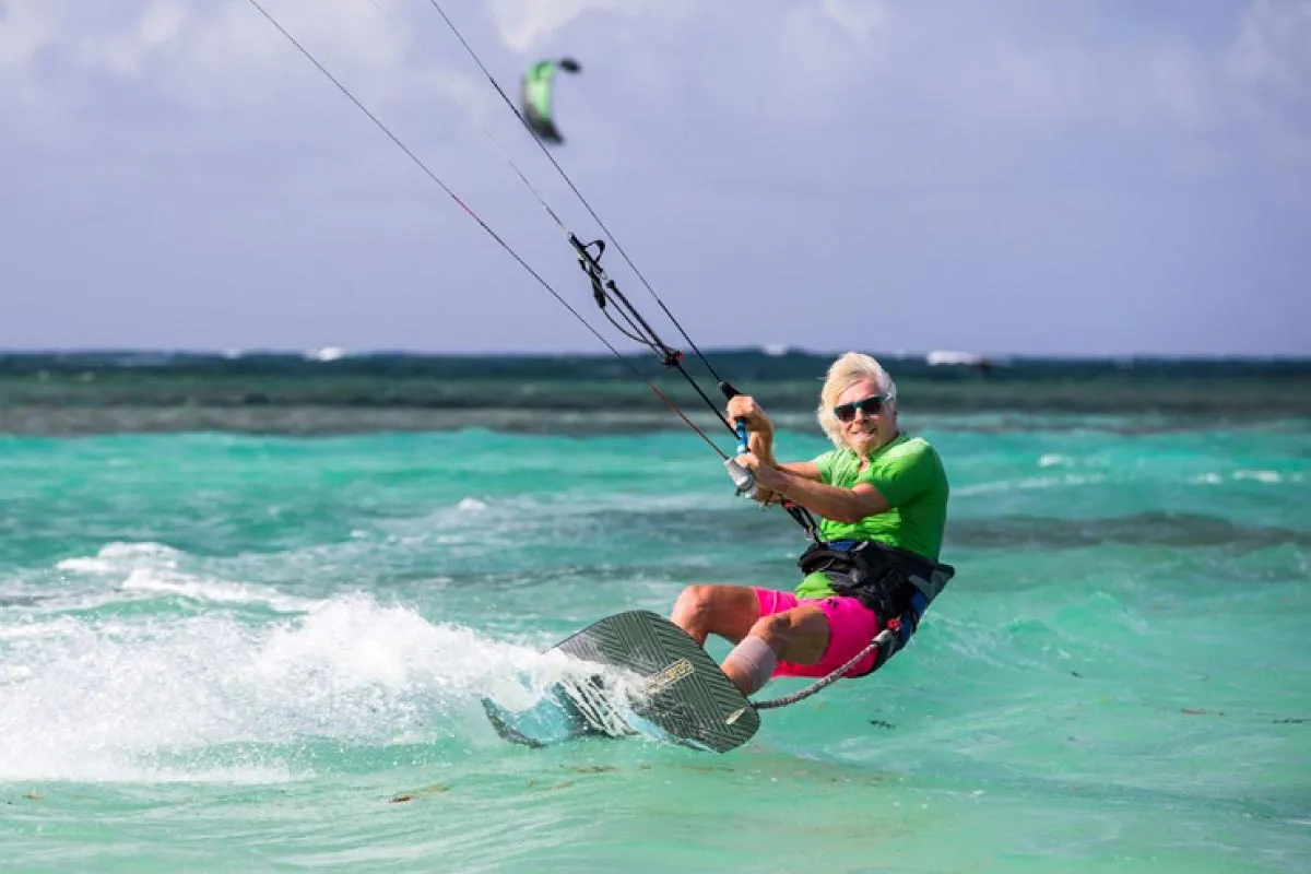 Richar Branson practicing kitesurf wearing bright colors.