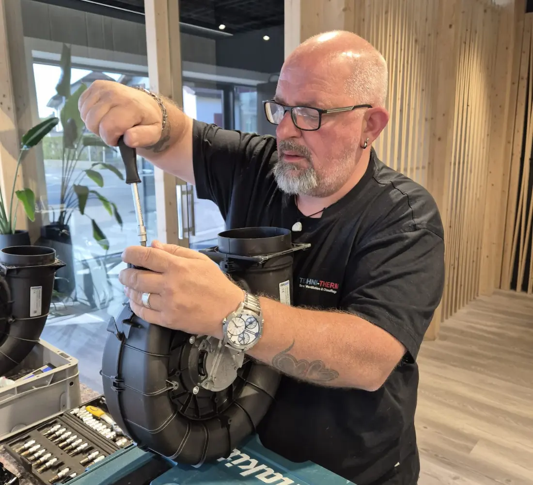 Technicien Techni-Therm en train d'entretenir un moteur de ventilation dans son atelier en Valais