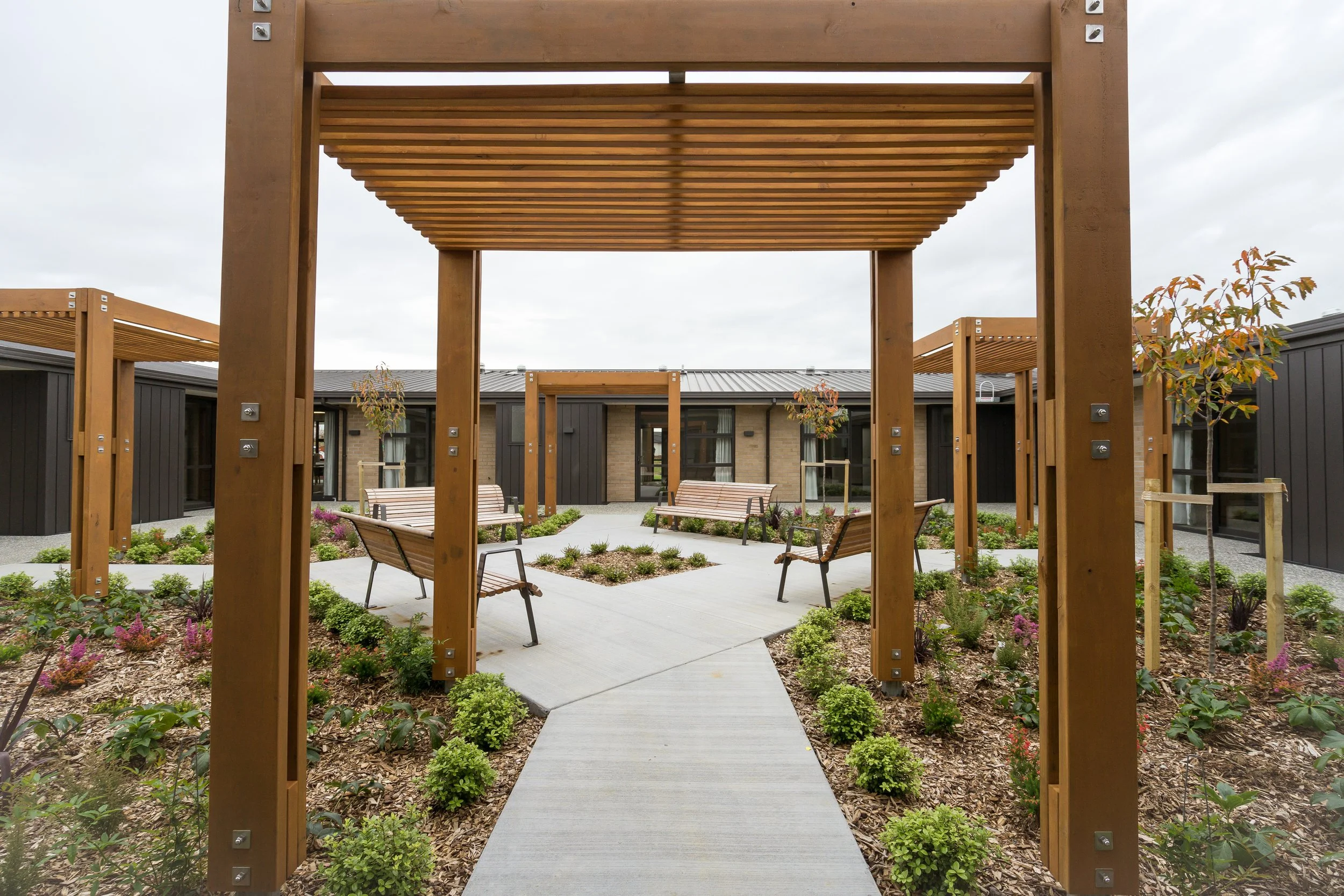 Timber pergola and mixed planting in aged care facility courtyard, Waikato