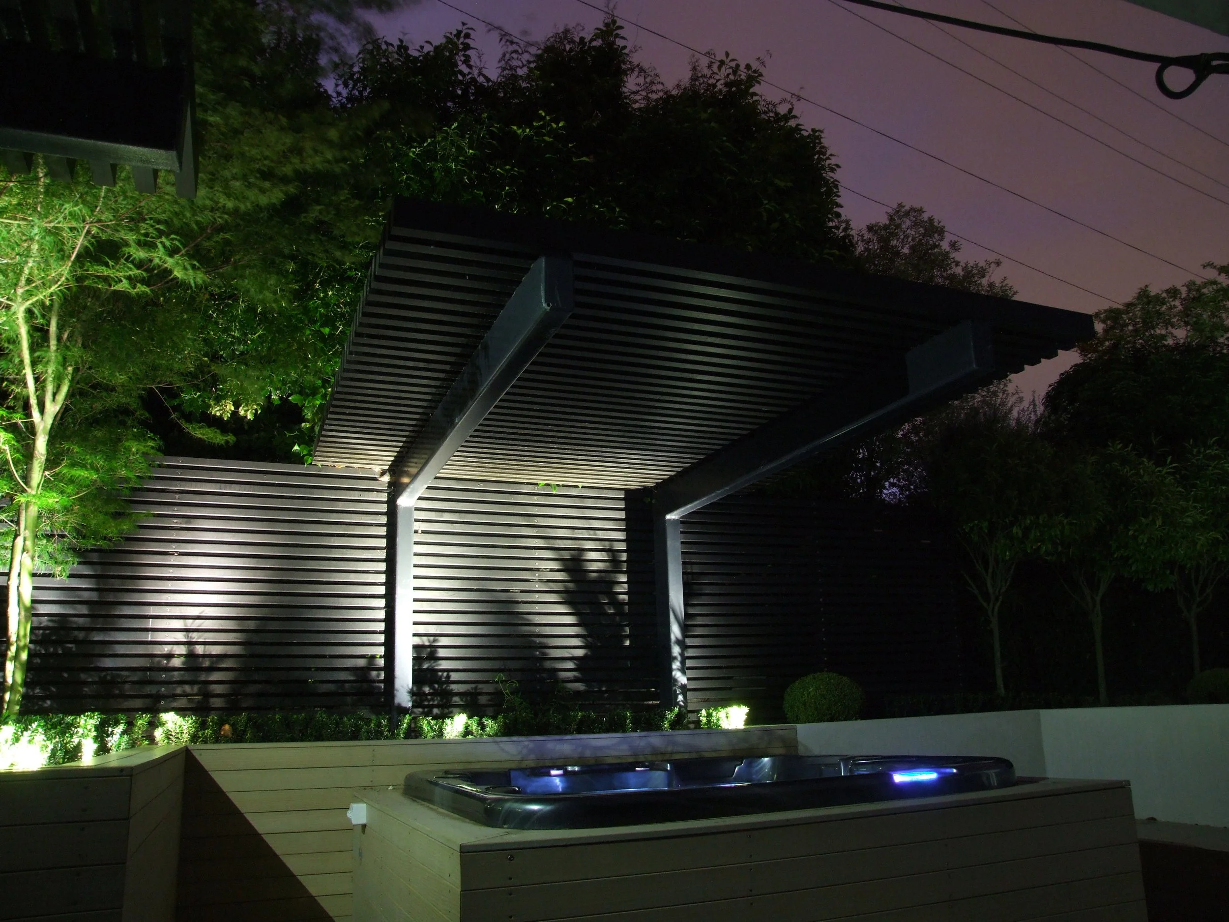 Illuminated louvre pergola with spa pool at night, Waikato